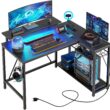 Bestier Small L Shaped Gaming Desk with Power Outlets,42 inch LED Computer Desk with Monitor Stand Reversible Storage Shelves Corner Gamer Desk with Headset Hooks USB Charging Port,Carbon Fiber Black - 1
